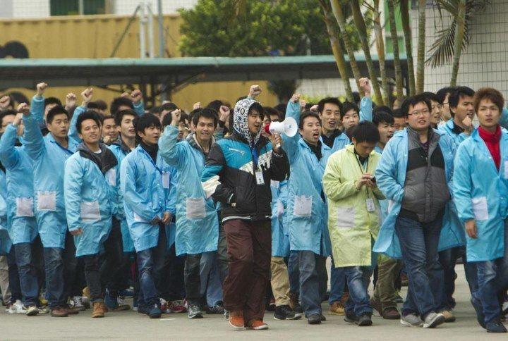 Chinese IBM workers on a marching tour of the factory after initiating a strike. REUTERS/Alex Lee