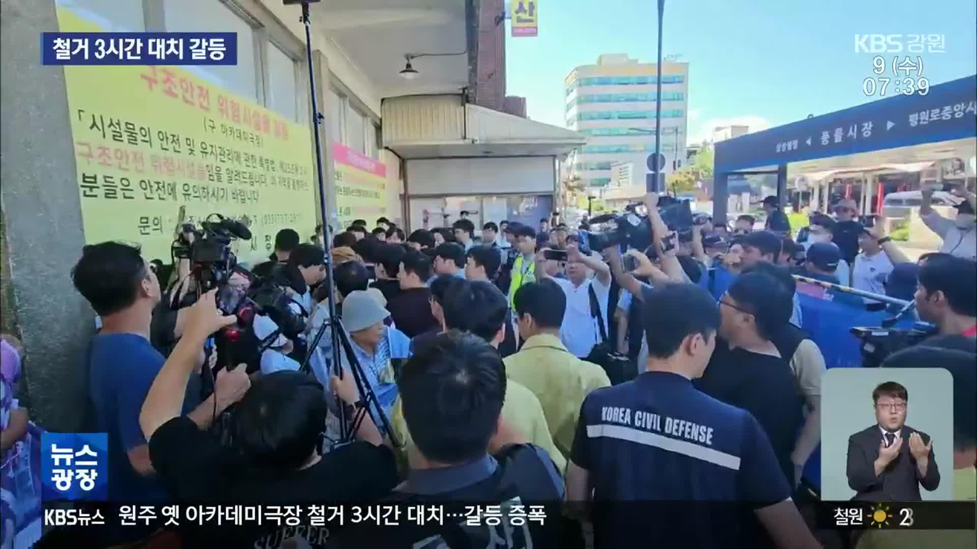 2023년 8월, 아카데미극장 철거를 위해 건물로 진입하려는 시청 공무원 및 용역들과 이에 맞서 극장을 지키는 시민들의 대치 상황 (KBS강원 뉴스화면)