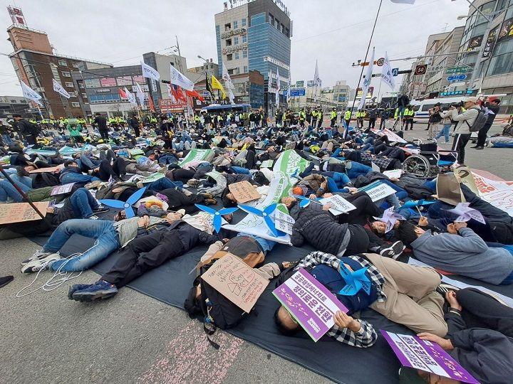 기후위기뿐 아니라 부정의한 기후 정책으로 모두 죽게 될 것이라고 경고하는 '다이인 퍼포먼스' 중인 행진 참가자들