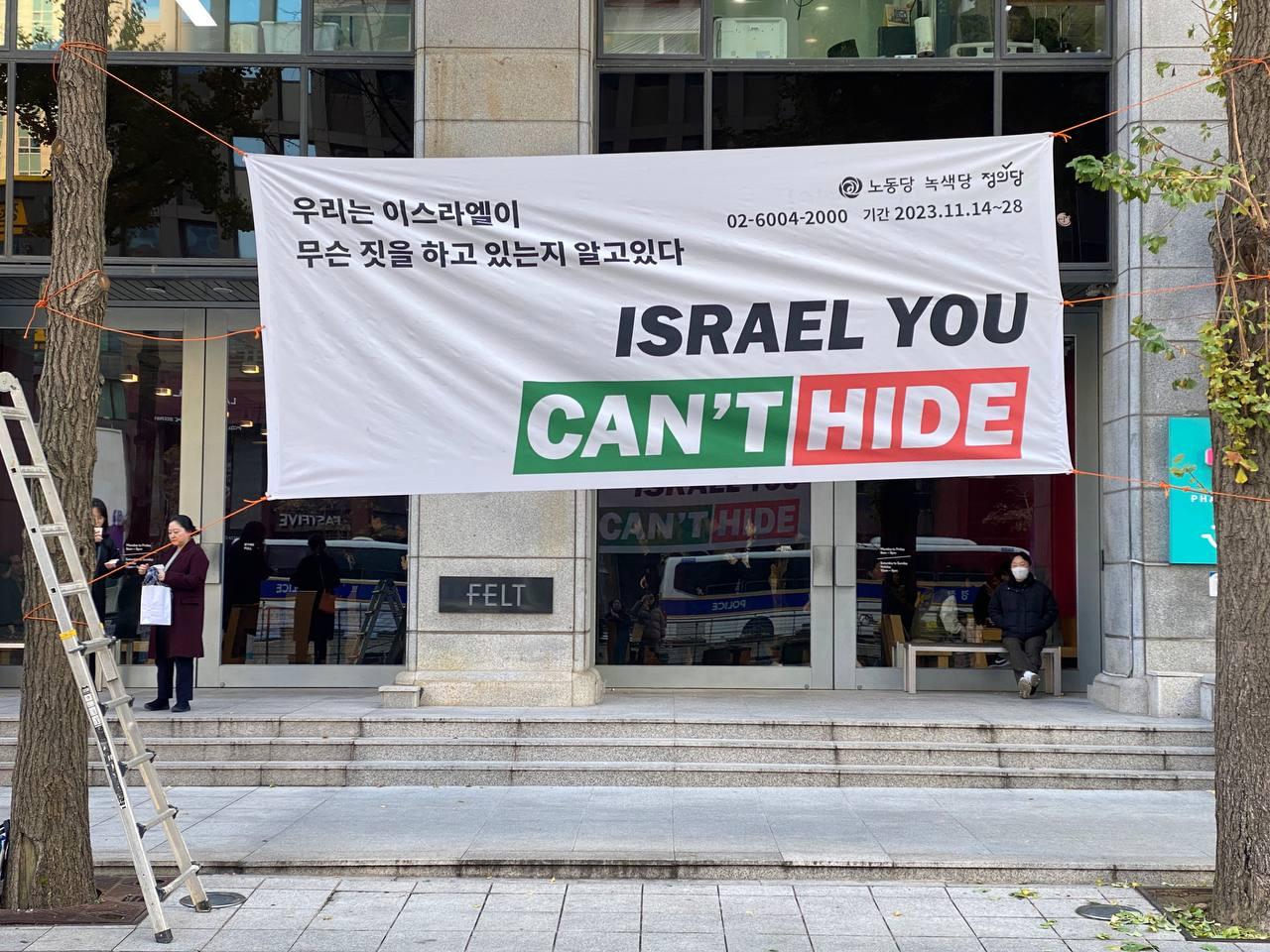 이스라엘 대사관 맞은편에 걸린 현수막 "우리는 이스라엘이 무슨 짓을 하고 있는지 알고 있다"